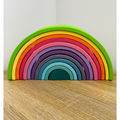 Colorful wooden rainbow toy on a wooden surface 