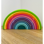 Colorful wooden rainbow toy on a wooden surface 